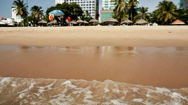 越南场景:芽庄海滩上的人们。在海滩上冲浪。专注于水视频素材