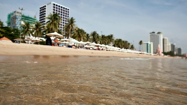 越南场景:芽庄海滩上的人们。在海滩上冲浪。专注于水视频素材