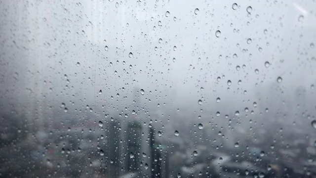 雨滴落在窗户玻璃与曼谷的城市景观背景视频素材