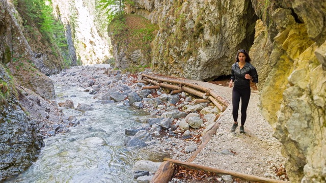 活跃的女人慢跑通过山涧山谷视频素材