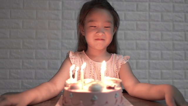 女孩在生日那天吹灭生日蛋糕上的蜡烛视频素材