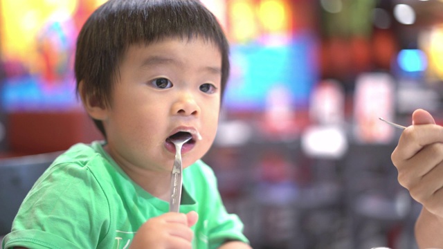 亚洲小男孩和妈妈在冰淇淋店吃冰淇淋视频素材