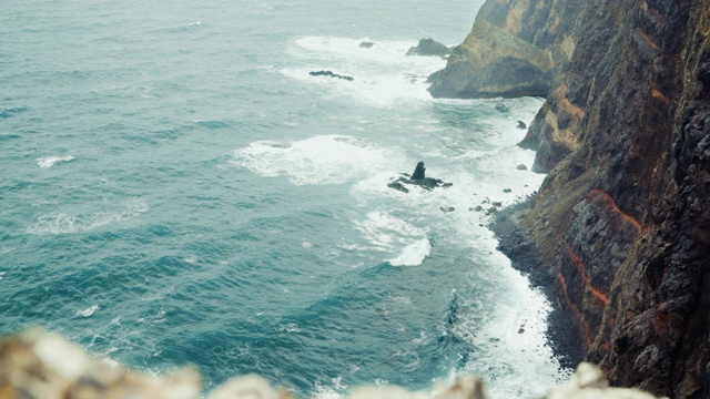 在葡萄牙马德拉，4K海浪翻滚到岩石海岸的航拍画面视频素材