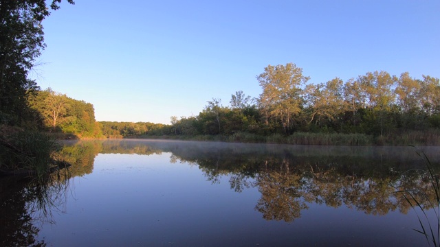 景观-雾蒙蒙的河流，时光流逝。早晨平静的河上有雾，树木倒映在水面上视频素材