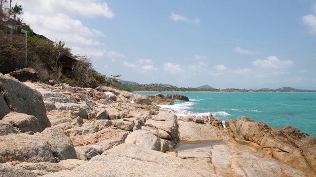 汹涌的海浪和水花拍打在带有海水泡沫的岩石海滩上。湛蓝的海水，海边，石头海岸视频素材