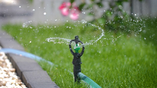 慢镜头洒水车把水溅到一片新鲜的草地上视频素材