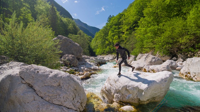 徒步旅行者在山中过河，跳过水视频素材