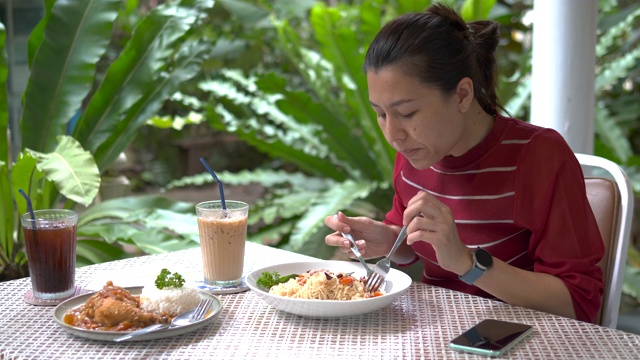 年轻的亚洲女人在吃东西视频素材