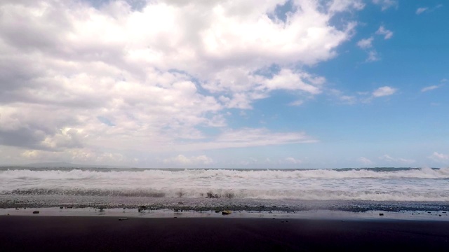 巨大的海浪拍打着黑色火山海滩的海岸。慢动作的观点。视频素材