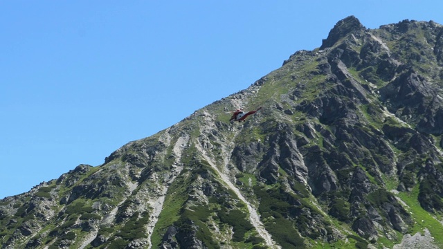 高山救援直升机在高山地区执行旅游救援任务视频素材