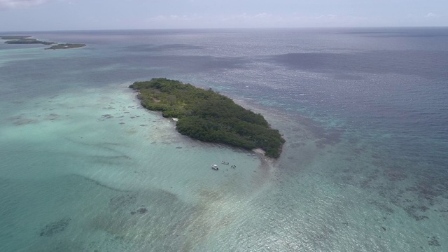 热带航空景观马塔科特岛与船和潜水员。鸟瞰无人机向后移动。等高右转。视频素材