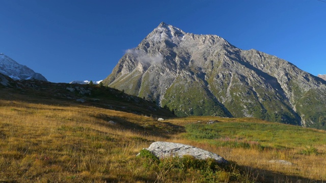 高山景观晨雾薄雾和云山谷山下的阿尔卑斯山脉和山峰，映衬着清澈的蓝天。视频素材