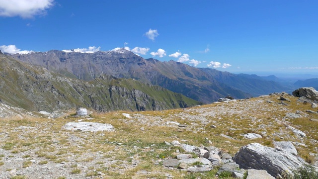 PAN:阿尔卑斯山脉的风景，在阿尔卑斯山脉和山峰下的山谷里，晨雾、薄雾和云，映衬着清澈的蓝天。视频素材