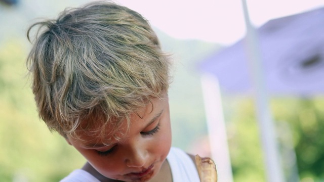 孩子吃冰淇淋。小男孩吃着冰淇淋甜点视频素材