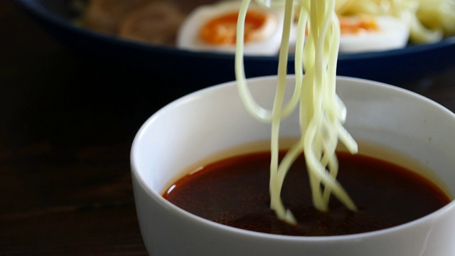 Hiroshima-style辣tsukemen。近距离视频浸泡面条在汤。视频素材