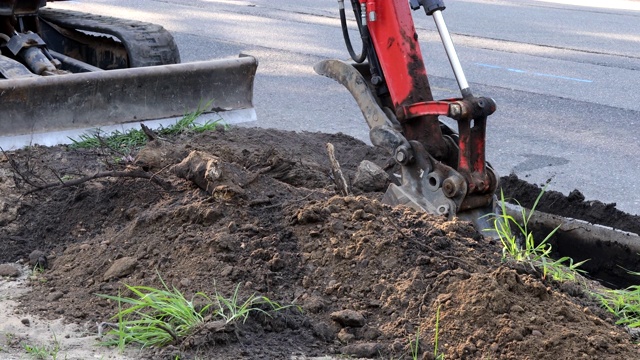 城市市政拖拉机用钢包在土方工程上挖下水道。视频素材