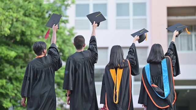 大学毕业生在毕业典礼上举起帽子祝贺他们视频素材