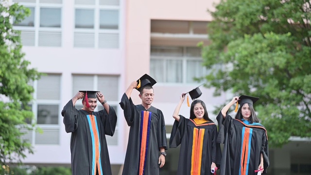 大学毕业生在毕业典礼上举起帽子祝贺他们视频素材