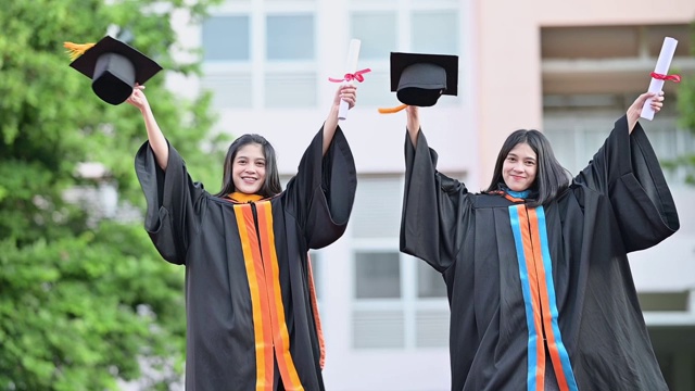 大学毕业生在毕业典礼上举起帽子祝贺他们视频素材