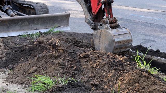 挖土机在道路上工作，挖掘机在开挖坑中施工视频素材