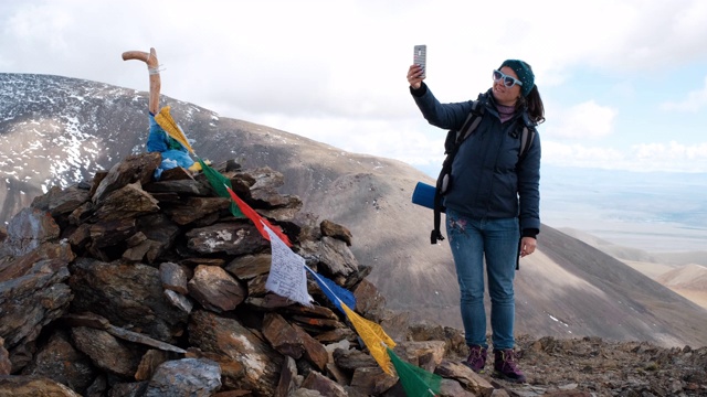 一名女性徒步旅行者在山顶自拍视频素材