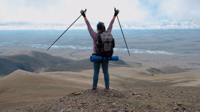 年轻的徒步旅行者在山顶张开双臂视频素材