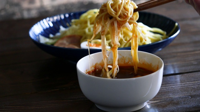 Hiroshima-style辣tsukemen。近距离视频浸泡面条在汤。视频素材