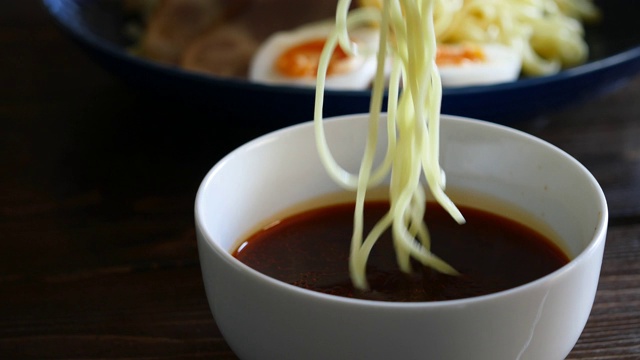 Hiroshima-style辣tsukemen。近距离视频浸泡面条在汤。视频素材