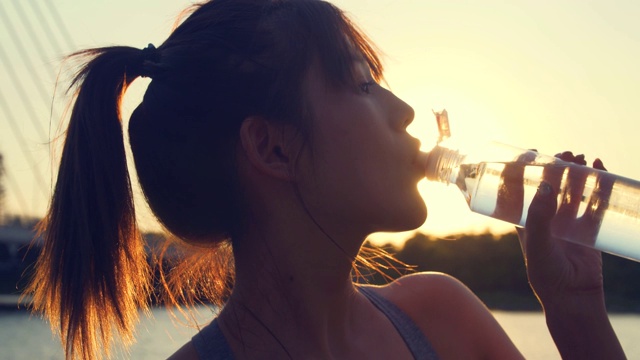 年轻女性在运动结束后喝水视频素材