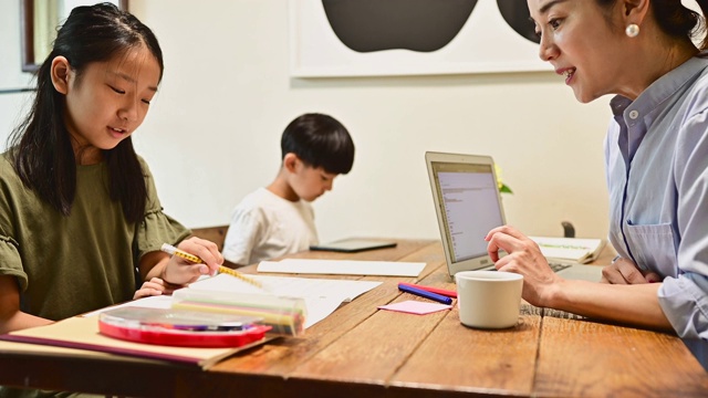 孩子们在家里学习。母亲在家工作教学习。视频素材