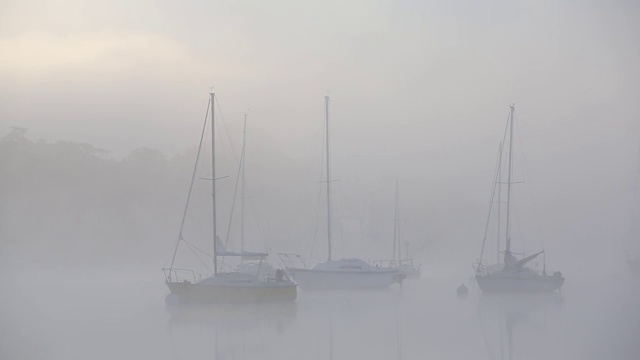 英国湖区温德米尔湖(Lake Windermere)，在薄雾中的日出上的帆船。视频素材