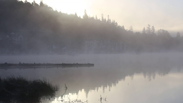 英国湖区温德米尔湖(Lake Windermere)，在薄雾中的日出上的帆船。视频素材