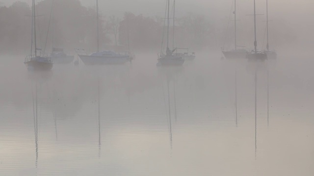 英国湖区温德米尔湖(Lake Windermere)，在薄雾中的日出上的帆船。视频素材