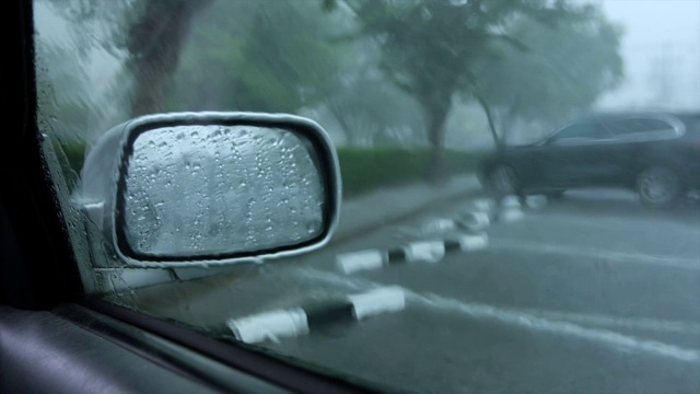 外面下着大雨，那辆车停在停车场里视频素材