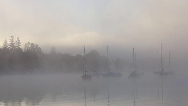 英国湖区温德米尔湖(Lake Windermere)，在薄雾中的日出上的帆船。视频素材