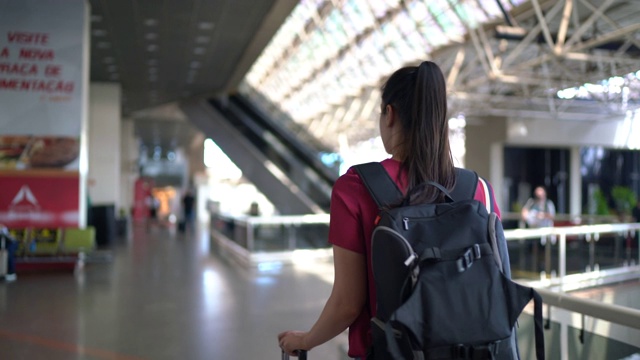 年轻的女旅行者在机场散步视频素材