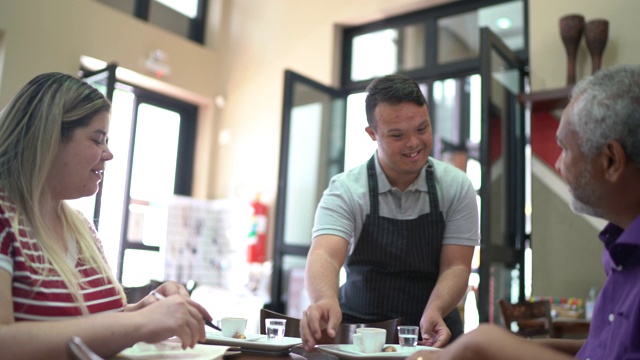 在咖啡店里，年轻人需要服务员为顾客端咖啡视频素材