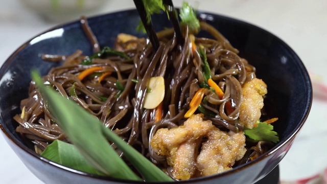 日本料理:黑碗炒荞麦面和蔬菜。美味，营养的亚洲食物视频下载