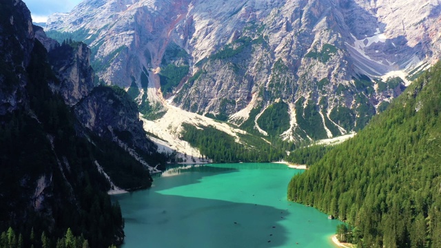 美丽的蓝色湖泊，与阳光反射在水中。景观与森林和山周围的湖在航空视图与无人机4K视频素材