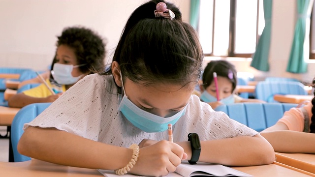 学生们戴着口罩在教室里学习视频素材