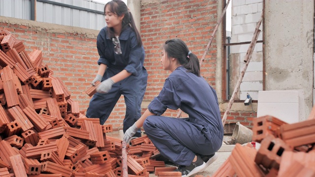 亚洲两个十几岁的女孩志愿工作一起建设一个住房项目。青少年活动视频素材