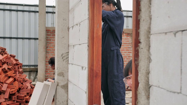 亚洲少女的志愿工作建设一个住房项目一起。青少年活动视频素材