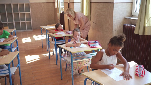 小学生在老师的指导下进行考试视频素材