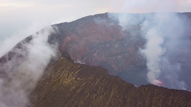 沿着尼拉贡戈活火山的火山口边缘飞行，熔岩湖喷出浓烟视频下载