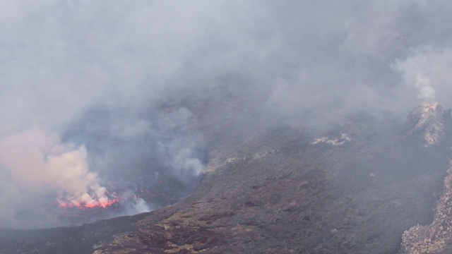 观察尼拉贡戈活火山的火山口，熔岩湖喷出浓烟视频素材