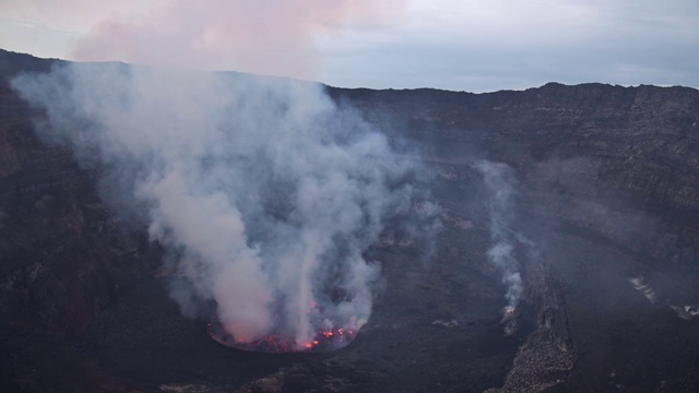 观察尼拉贡戈活火山的火山口，熔岩湖喷出浓烟视频下载