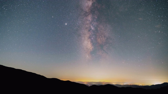 时间流逝的镜头，银河系通过天空在一个小城镇视频素材