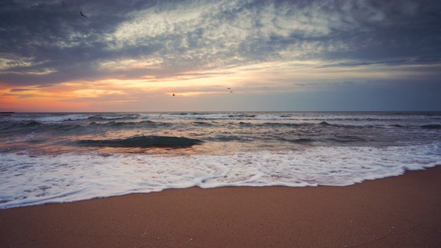 海上日出在海滩上与戏剧性的云景视频素材