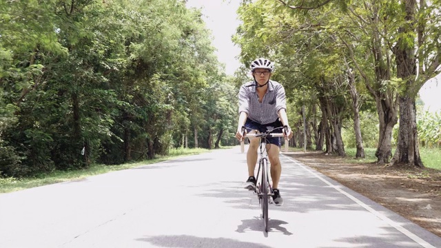 亚洲骑自行车的人在路上骑公路自行车。视频素材