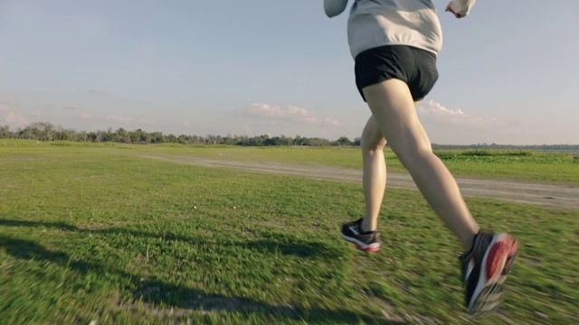 亚洲女性在乡村公路上跑步，山景美丽的日落。视频素材